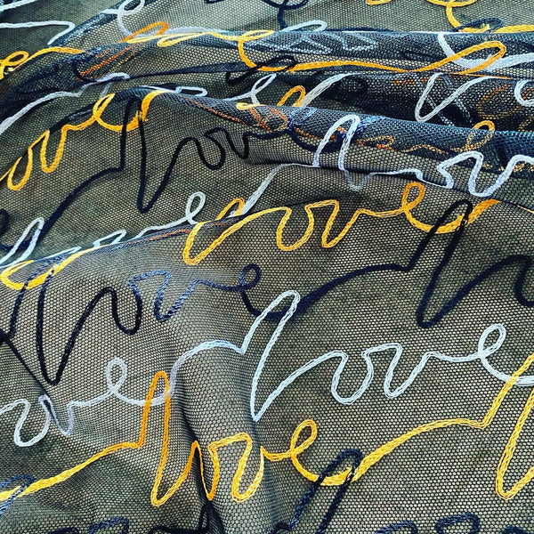Broderie rigide légère LOVE jaune noir et blanc sur filet de tulle en maille noire - 1 m